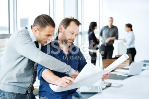 stock-photo-20813408-architects-analyzing-blueprint